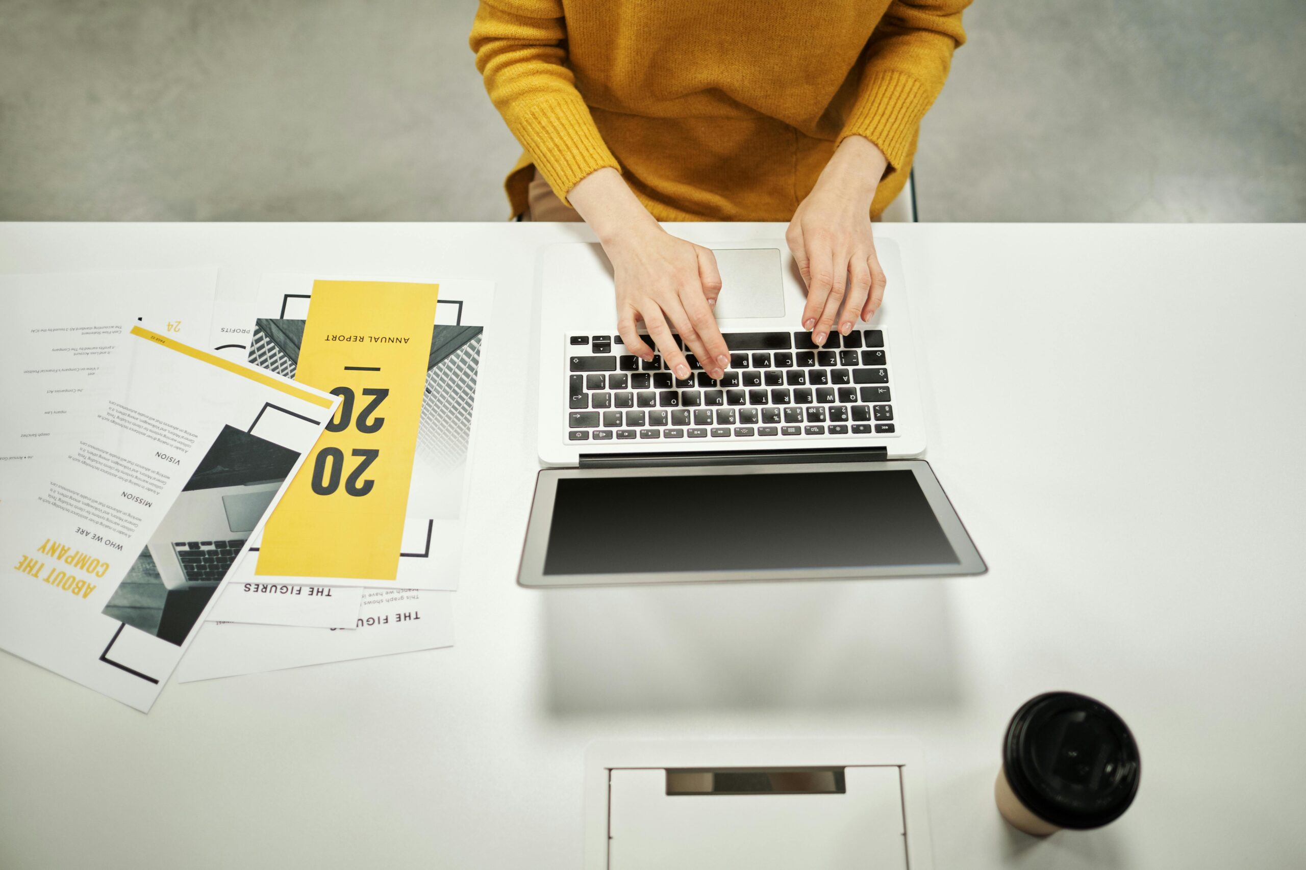 Top-down view of person typing on laptop at desk