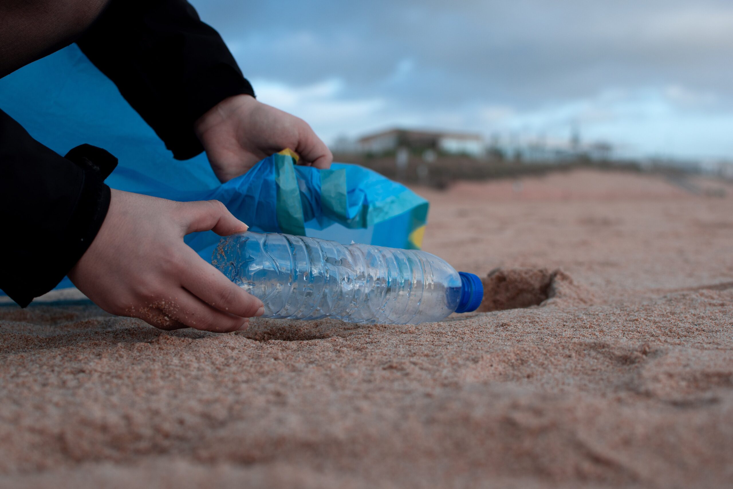 Individual gathering refuse on the shore during a volunteer event