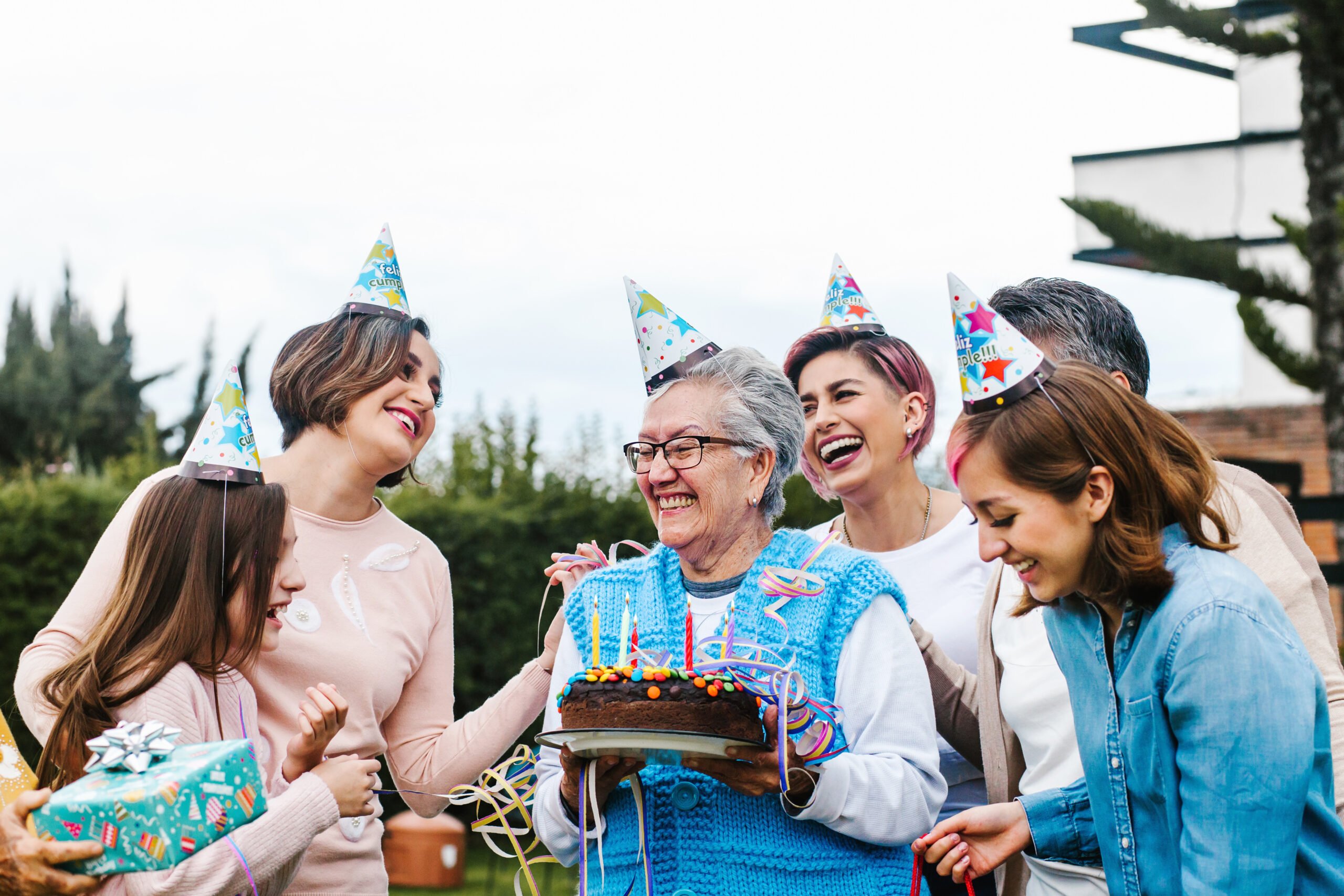 adobestock_397909185-scaled-1 Mom holding a birthday cake surrounded by family